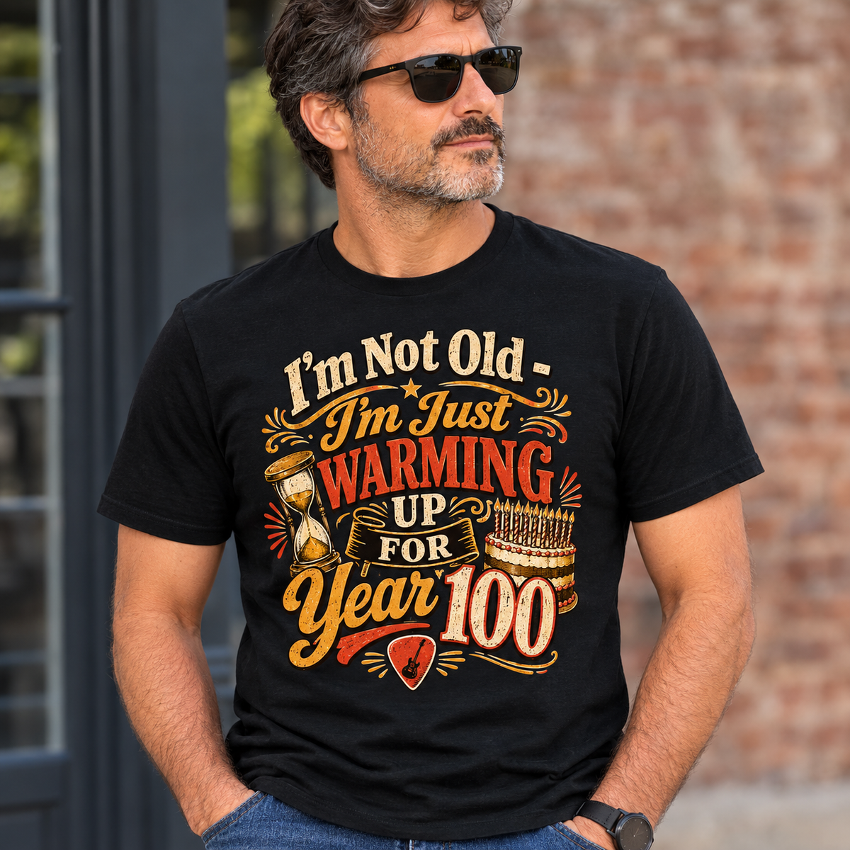 Man wearing a black t-shirt printed with "I'm Not Old - I'm Just Warming Up For Year 100"